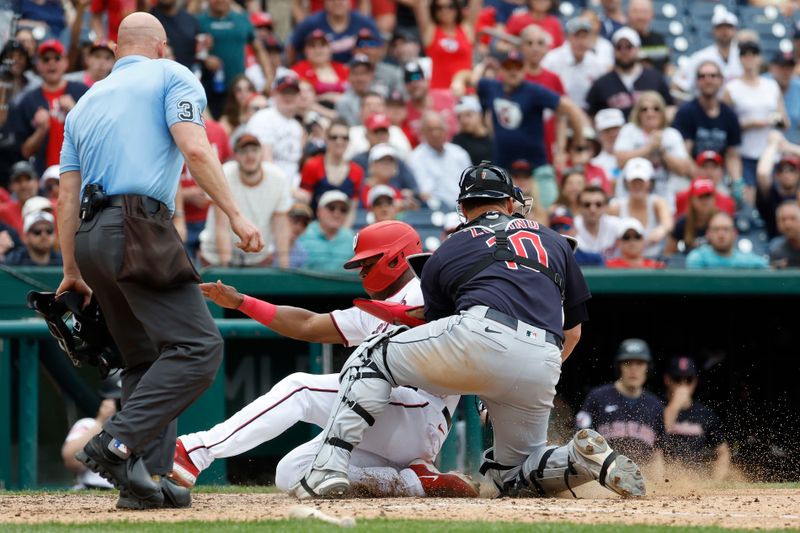 Apr 16, 2023; Washington, District of Columbia, USA; Washington Nationals left fielder Stone Garrett (36) collides with Cleveland Guardians catcher Mike Zunino (10) at home plate while attempting to score a run on a sacrifice fly hit by Nationals right fielder Lane Thomas (not pictured) during the eighth inning at Nationals Park. Garrett was ruled safe after the call on the field was overturned after a challenge review by the Nationals. Mandatory Credit: Geoff Burke-USA TODAY Sports