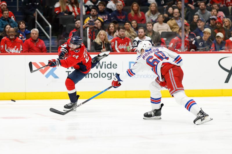 Dec 23, 2025; Washington, District of Columbia, USA; Washington Capitals center Connor McMichael (24) shoots the puck as New York Rangers defenseman Scott Morrow (60) defends during the third period at Capital One Arena. Mandatory Credit: Geoff Burke-Imagn Images