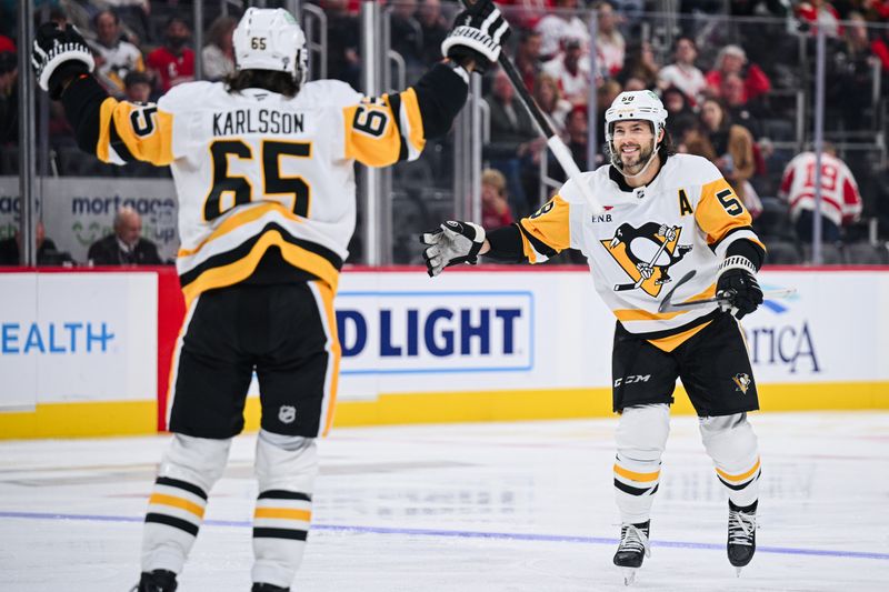 Oct 10, 2024; Detroit, Michigan, USA; Pittsburgh Penguins defenseman Erik Karlsson (65) celebrates his goal with defenseman Kris Letang (58) during the third period at Little Caesars Arena. Mandatory Credit: Tim Fuller-Imagn Images