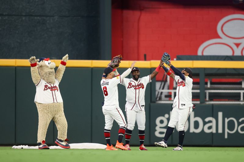 Sep 7, 2023; Atlanta, Georgia, USA; Atlanta Braves mascot Blooper and left fielder Eddie Rosario (8) and center fielder Michael Harris II (23) and right fielder Ronald Acuna Jr. (13) celebrate a victory against the St. Louis Cardinals at Truist Park. Mandatory Credit: Brett Davis-USA TODAY Sports

