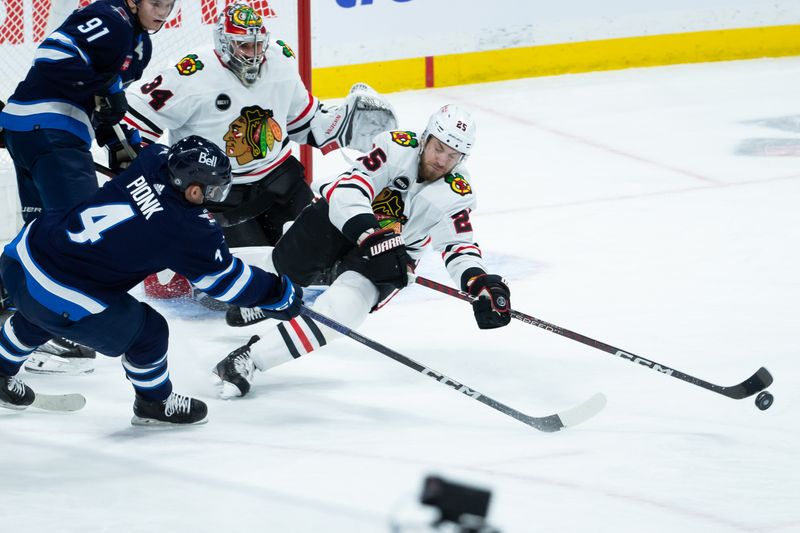 Jan 11, 2024; Winnipeg, Manitoba, CAN; Chicago Blackhawks defenseman Jarred Tinordi (25) clears the puck away from Winnipeg Jets defenseman Neal Pionk (4) during the third period at Canada Life Centre. Mandatory Credit: Terrence Lee-USA TODAY Sports