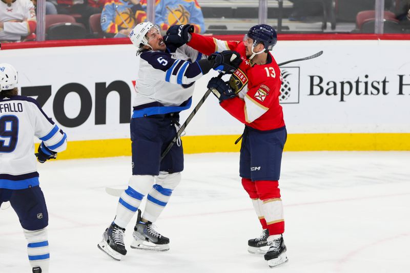 Nov 24, 2023; Sunrise, Florida, USA; Winnipeg Jets defenseman Brenden Dillon (5) and Florida Panthers center Sam Reinhart (13) fight during the third period at Amerant Bank Arena. Mandatory Credit: Sam Navarro-USA TODAY Sports