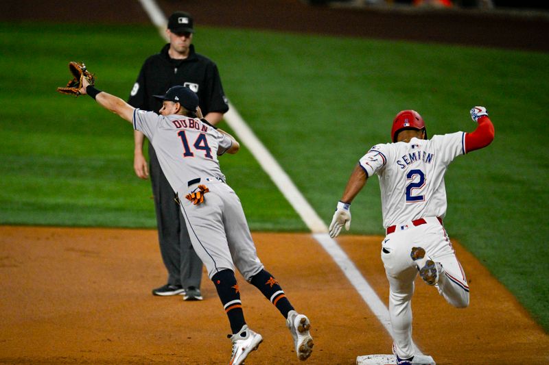 Aug 5, 2024; Arlington, Texas, USA; Texas Rangers second baseman Marcus Semien (2) beats out the throw to Houston Astros first baseman Mauricio Dubon (14) during the first inning at Globe Life Field. Mandatory Credit: Jerome Miron-USA TODAY Sports