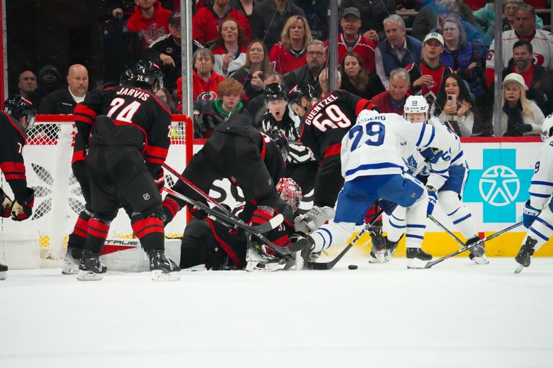 Mar 24, 2024; Raleigh, North Carolina, USA;  Carolina Hurricanes goaltender Frederik Andersen (31) stops the scoring chance by Toronto Maple Leafs right wing Pontus Holmberg (29) during the third period at PNC Arena. Mandatory Credit: James Guillory-USA TODAY Sports