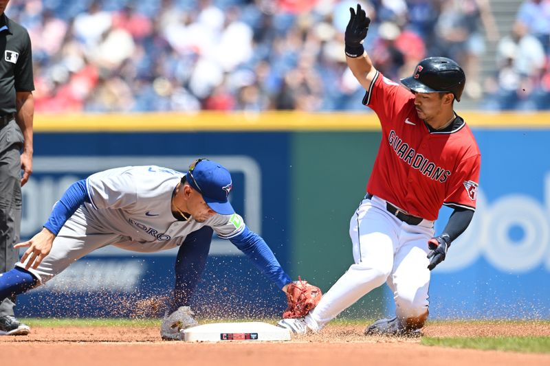 Jun 26, 2025; Cleveland, Ohio, USA; Cleveland Guardians left fielder Steven Kwan (38) slides into second with a double as Toronto Blue Jays second baseman Andres Gimenez (0) is late with the tag during the first inning at Progressive Field. Mandatory Credit: Ken Blaze-Imagn Images