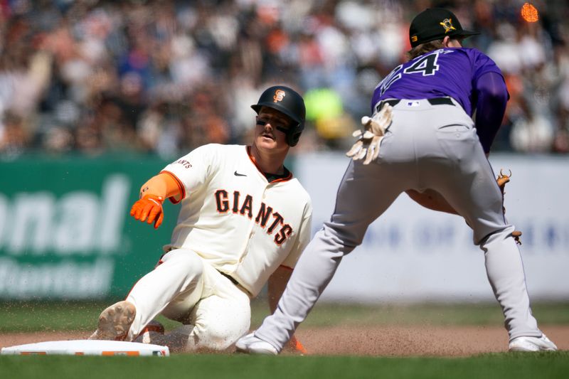 May 18, 2024; San Francisco, California, USA; San Francisco Giants third baseman Matt Chapman (26) slides safely into third base ahead of the relay to Colorado Rockies third baseman Ryan McMahon (24) on a double and an error during the seventh inning at Oracle Park. Mandatory Credit: D. Ross Cameron-USA TODAY Sports