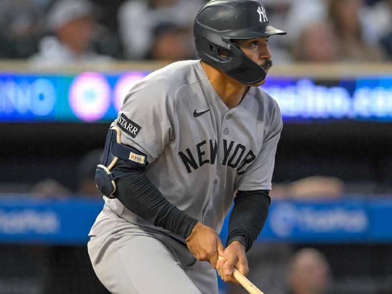 Sep 17, 2025; Minneapolis, Minnesota, USA;  New York Yankees outfielder Trent Grisham (12) hits a solo home run against the Minnesota Twins during the third inning at Target Field. Mandatory Credit: Nick Wosika-Imagn Images