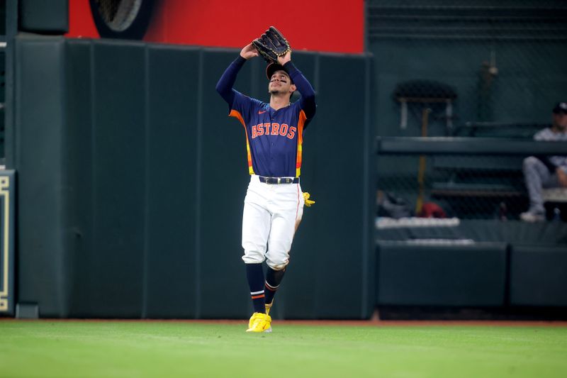 Jun 1, 2024; Houston, Texas, USA; Houston Astros left fielder Mauricio Dubon (14) reaches up to catch a fly ball for an out against the Minnesota Twins during the ninth inning at Minute Maid Park. Mandatory Credit: Erik Williams-USA TODAY Sports