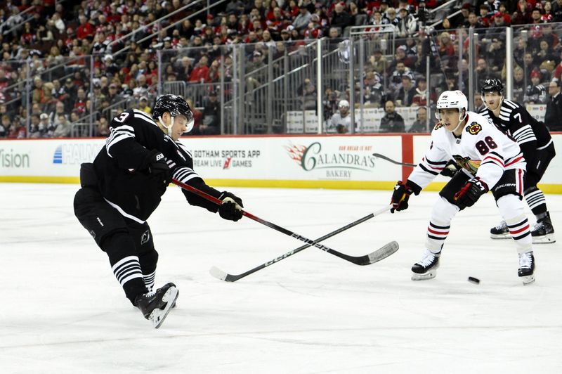 Dec 14, 2024; Newark, New Jersey, USA; New Jersey Devils left wing Jesper Bratt (63) shoots the puck as Chicago Blackhawks center Teuvo Teravainen (86) defends during the second period at Prudential Center. Mandatory Credit: John Jones-Imagn Images