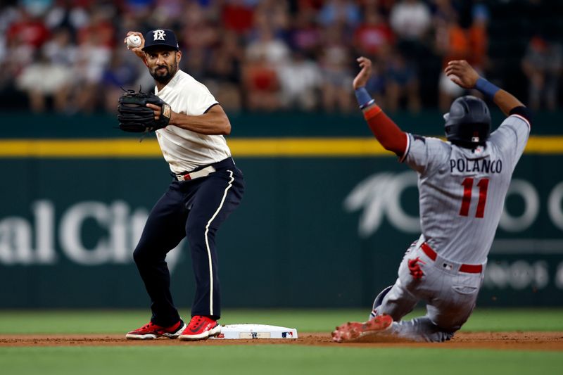 Sep 2, 2023; Arlington, Texas, USA; Texas Rangers second baseman Marcus Semien (2) turns a double play on Minnesota Twins designated hitter Jorge Polanco (11) in the first inning at Globe Life Field. Mandatory Credit: Tim Heitman-USA TODAY Sports