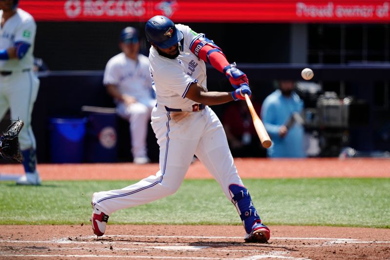 Jul 28, 2024; Toronto, Ontario, CAN; Toronto Blue Jays first baseman Vladimir Guerrero Jr. (27) hts a solo home run against the Texas Rangers  during the third inning at Rogers Centre. Mandatory Credit: John E. Sokolowski-USA TODAY Sports