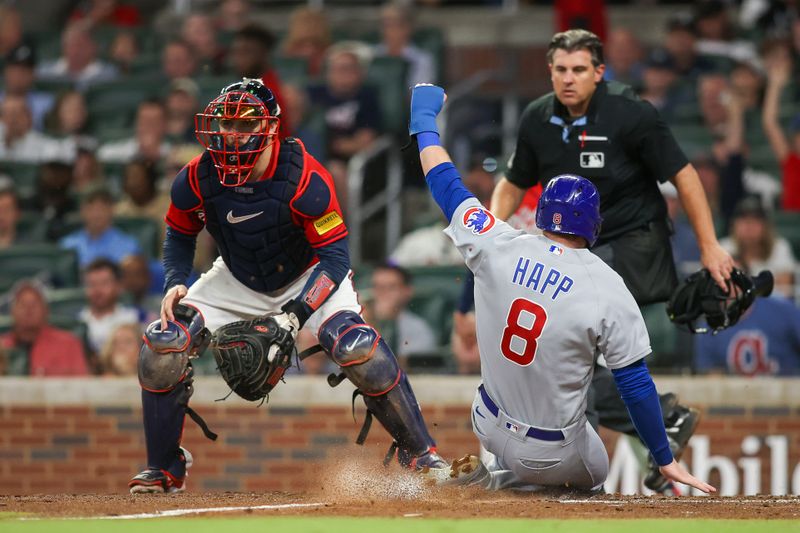 Sep 28, 2023; Atlanta, Georgia, USA; Chicago Cubs left fielder Ian Happ (8) scores a run against Atlanta Braves catcher Travis d'Arnaud (16) in the sixth inning at Truist Park. Mandatory Credit: Brett Davis-USA TODAY Sports