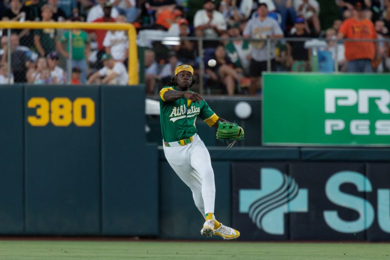 Jul 6, 2025; West Sacramento, California, USA; Athletics right fielder Lawrence Butler (4) looks to throw the ball to second base after a single by San Francisco Giants catcher Andrew Knizner (21) during the fifth inning at Sutter Health Park. Mandatory Credit: Sergio Estrada-Imagn Images