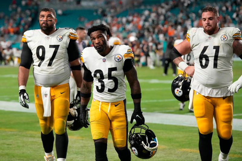 Pittsburgh Steelers defensive tackle Cameron Heyward (97), cornerback Arthur Maulet (35) and center Mason Cole (61) exit the field at the end of an NFL football game, Sunday, Oct. 23, 2022, in Miami Gardens, Fla. The Dolphins defeated the Steelers 16-10. (AP Photo/Rebecca Blackwell)