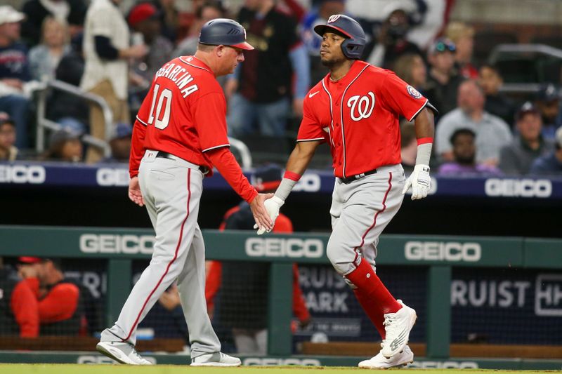 Apr 11, 2022; Atlanta, Georgia, USA; Washington Nationals third baseman Maikel Franco (right) celebrates with third base coach Gary Disarcina (10) after hitting a two-run home run against the Atlanta Braves in the third inning at Truist Park. Mandatory Credit: Brett Davis-USA TODAY Sports