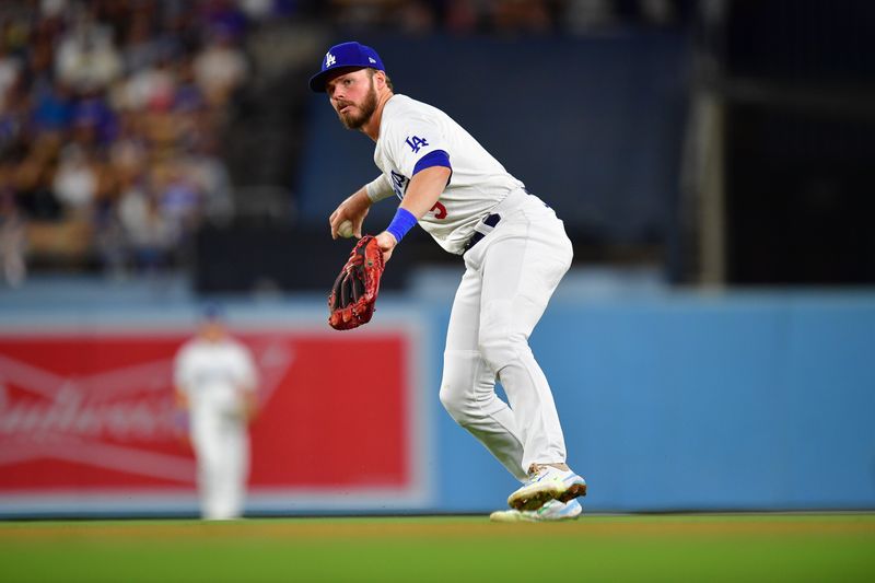 Aug 19, 2024; Los Angeles, California, USA; Los Angeles Dodgers second baseman Gavin Lux (9) throws to first for the out against Seattle Mariners third baseman Josh Rojas (4) during the eighth inning at Dodger Stadium. Mandatory Credit: Gary A. Vasquez-USA TODAY Sports