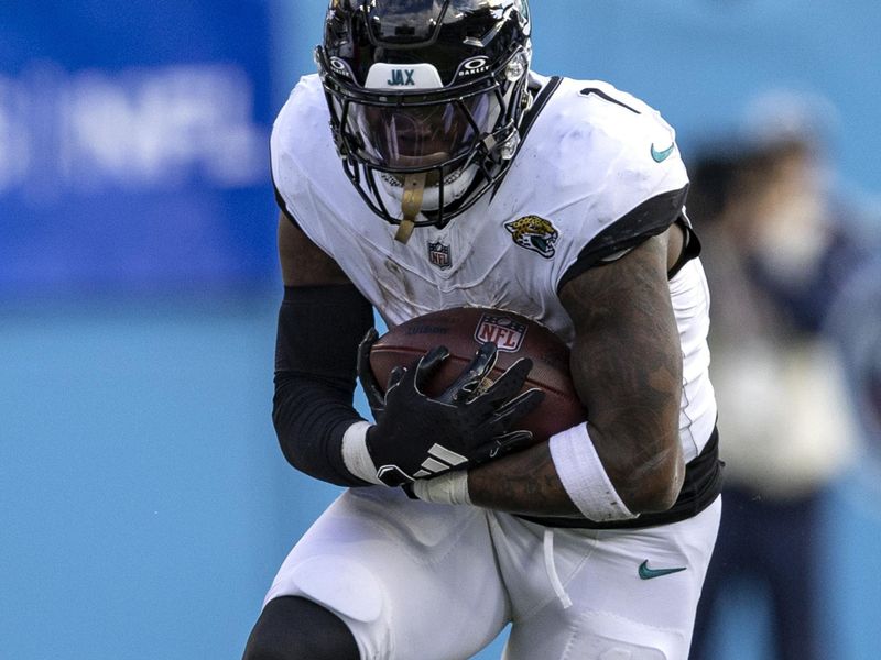 Jacksonville Jaguars running back Travis Etienne Jr. (1) runs for yardage during their NFL football game against the Tennessee Titans Sunday, Jan. 7, 2024, in Nashville, Tenn. (AP Photo/Wade Payne)