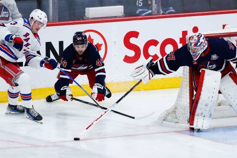 Mar 12, 2026; Winnipeg, Manitoba, CAN; Winnipeg Jets goalie Connor Hellebuyck (37) pokes the puck away from New York Rangers forward Alexis Lafreniere (13) and Winnipeg Jets defenseman Josh Morrissey (44) during the second period at Canada Life Centre. Mandatory Credit: Terrence Lee-Imagn Images