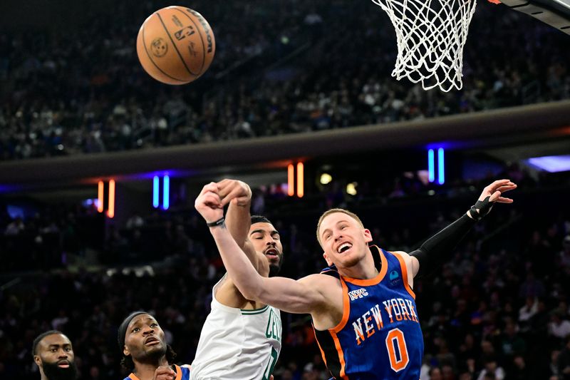 NEW YORK, NEW YORK - FEBRUARY 24:  Jayson Tatum #0 of the Boston Celtics and Donte DiVincenzo #0 of the New York Knicks battle for the rebound during the second half at Madison Square Garden on February 24, 2024 in New York City. NOTE TO USER: User expressly acknowledges and agrees that, by downloading and or using this photograph, User is consenting to the terms and conditions of the Getty Images License Agreement. (Photo by Steven Ryan/Getty Images)