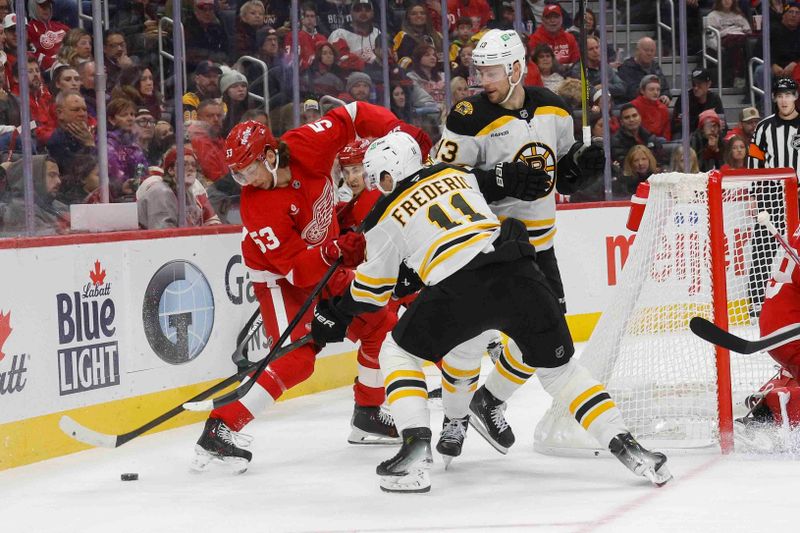 Nov 23, 2024; Detroit, Michigan, USA; Detroit Red Wings defenseman Moritz Seider (53) handles the puck against Boston Bruins center Trent Frederic (11) during the third period at Little Caesars Arena. Mandatory Credit: Brian Bradshaw Sevald-Imagn Images