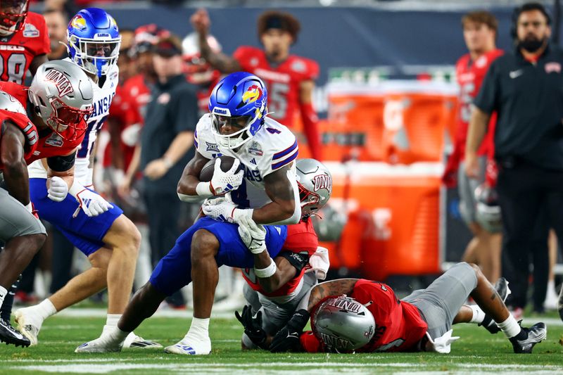 Dec 26, 2023; Phoenix, AZ, USA; Kansas Jayhawks running back Devin Neal (4) runs with the ball during the first quarter against the UNLV Rebels in the Guaranteed Rate Bowl at Chase Field. Mandatory Credit: Mark J. Rebilas-USA TODAY Sports