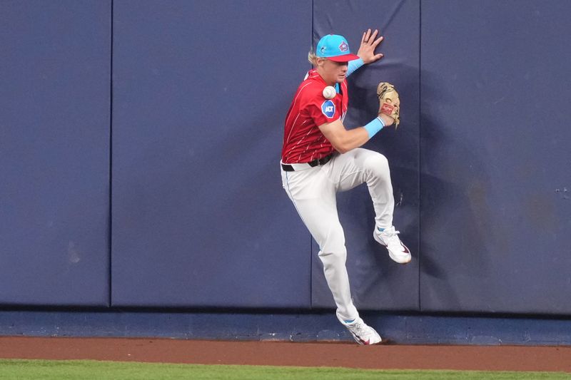 Sep 7, 2024; Miami, Florida, USA;  Miami Marlins center fielder Kyle Stowers (28) collides with the wall while trying to catch a fly ball in the fourth inning against the Philadelphia Phillies at loanDepot Park. Mandatory Credit: Jim Rassol-Imagn Images