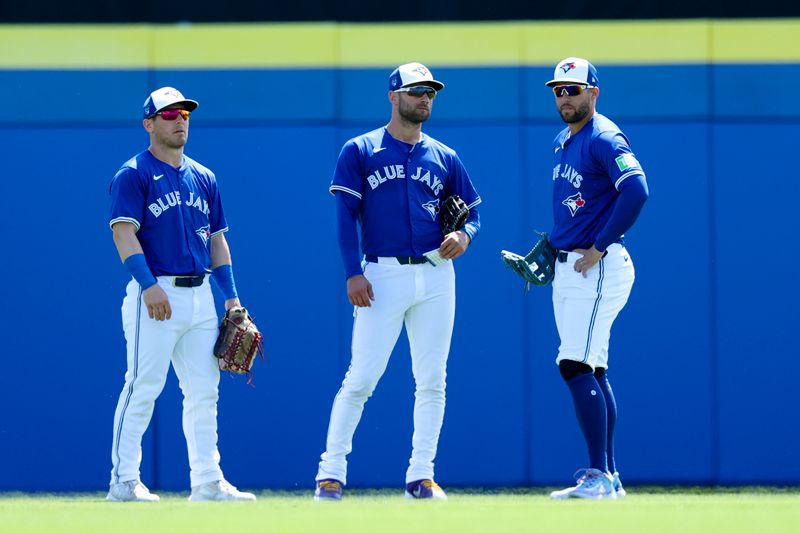 Mar 12, 2024; Dunedin, Florida, USA;  Toronto Blue Jays left fielder Daulton Varsho (25) center fielder Kevin Kiermaier (39) and right fielder George Springer (4) wait for a pitching change against the New York Yankees in the first inning at TD Ballpark. Mandatory Credit: Nathan Ray Seebeck-USA TODAY Sports