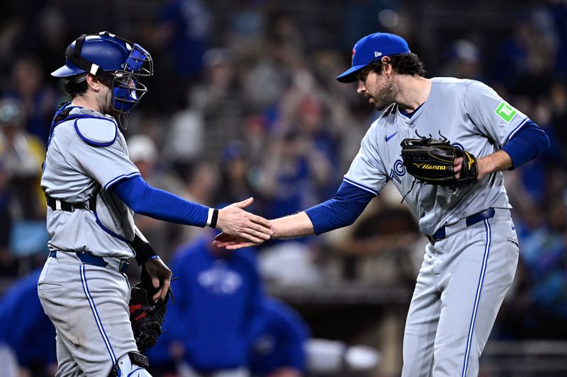 Apr 19, 2024; San Diego, California, USA; Toronto Blue Jays relief pitcher Jordan Romano (right) and catcher Danny Jansen (9) celebrate on the field after defeating the San Diego Padres at Petco Park. Mandatory Credit: Orlando Ramirez-USA TODAY Sports 