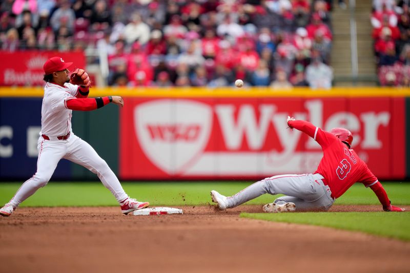 April 21, 2024; Cincinnati, Ohio, USA; Cincinnati Reds second base Santiago Espinal (4) throws to first base to complete a double as Los Angeles Angels outfielder Taylor Ward (3) slides into second base in the sixth inning at Great American Ball Park. Mandatory Credit: Kareem Elgazzar/USA TODAY Sports via The Cincinnati Enquirer

