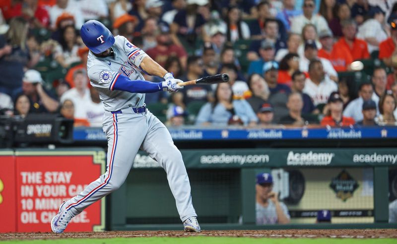 Apr 14, 2024; Houston, Texas, USA; Texas Rangers second baseman Marcus Semien (2) hits an RBI double during the fifth inning against the Houston Astros at Minute Maid Park. Mandatory Credit: Troy Taormina-USA TODAY Sports