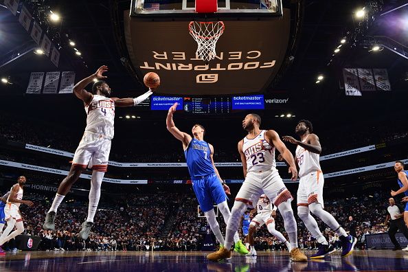 PHOENIX, AZ - DECEMBER 25: Chimezie Metu #4 of the Phoenix Suns grabs the rebound during the game against the Dallas Mavericks on December 25, 2023 at Footprint Center in Phoenix, Arizona. NOTE TO USER: User expressly acknowledges and agrees that, by downloading and or using this photograph, user is consenting to the terms and conditions of the Getty Images License Agreement. Mandatory Copyright Notice: Copyright 2023 NBAE (Photo by Barry Gossage/NBAE via Getty Images)