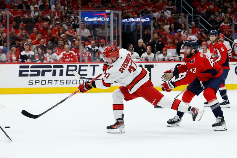 May 6, 2025; Washington, District of Columbia, USA; Carolina Hurricanes right wing Andrei Svechnikov (37) shoots the puck as Washington Capitals right wing Tom Wilson (43) defends in the second period in game one of the second round of the 2025 Stanley Cup Playoffs at Capital One Arena. Mandatory Credit: Geoff Burke-Imagn Images