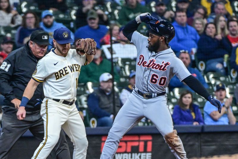 Apr 26, 2023; Milwaukee, Wisconsin, USA; Detroit Tigers left fielder Akil Baddoo (60) advances to third base on a fly ball hit by catcher Jake Rogers (not pictured) in the seventh inning as Milwaukee Brewers third baseman Mike Brosseau (10) looks on at American Family Field. Mandatory Credit: Benny Sieu-USA TODAY Sports