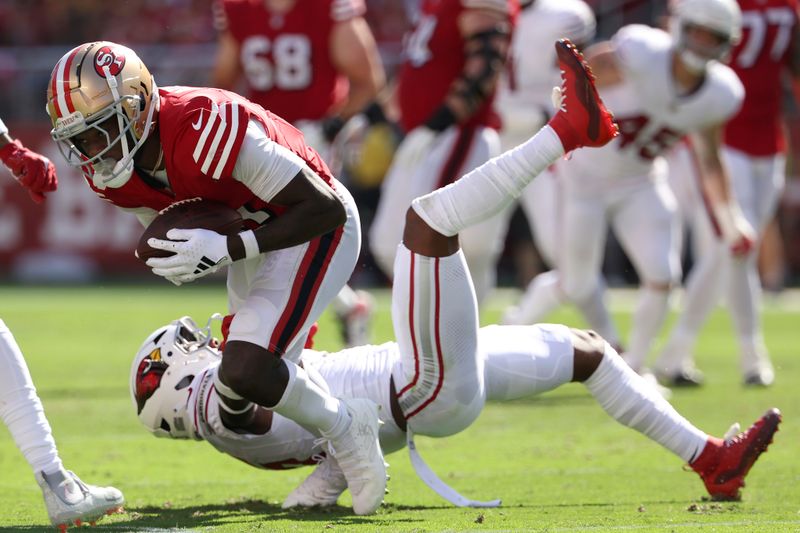 San Francisco 49ers wide receiver Brandon Aiyuk, top, runs against Arizona Cardinals safety Budda Baker during the first half of an NFL football game in Santa Clara, Calif., Sunday, Oct. 6, 2024. (AP Photo/Jed Jacobsohn)