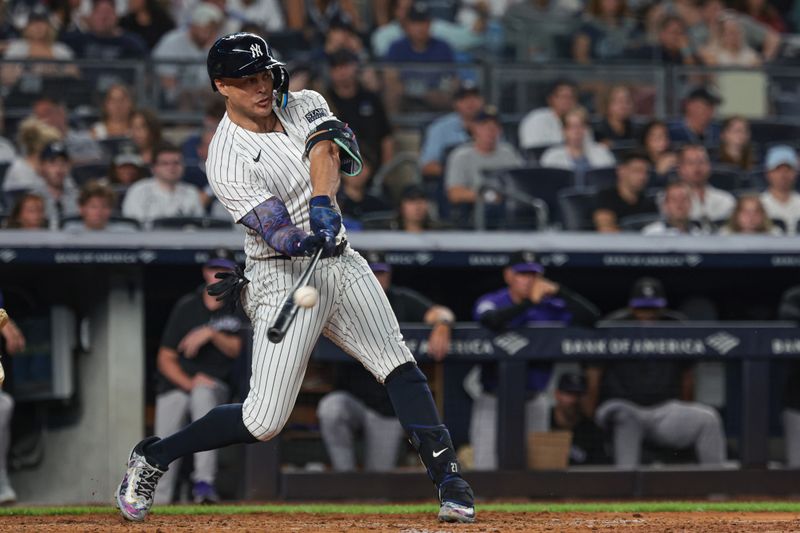 Aug 23, 2024; Bronx, New York, USA;  New York Yankees designated hitter Giancarlo Stanton (27) hits a solo home run during the fourth inning against the Colorado Rockies at Yankee Stadium. Mandatory Credit: Vincent Carchietta-USA TODAY Sports