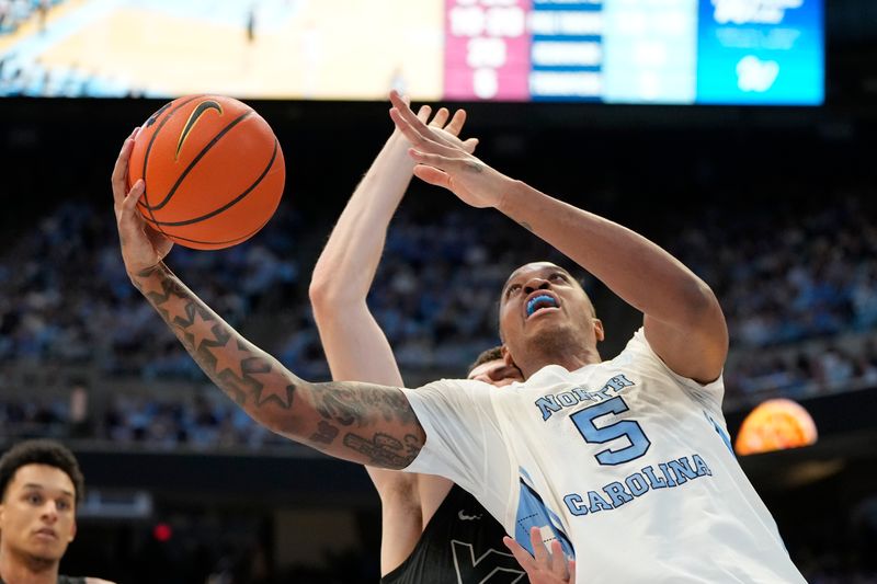 Feb 17, 2024; Chapel Hill, North Carolina, USA; North Carolina Tar Heels forward Armando Bacot (5) shoots as Virginia Tech Hokies forward Robbie Beran (31) defends in the second half at Dean E. Smith Center. Mandatory Credit: Bob Donnan-USA TODAY Sports