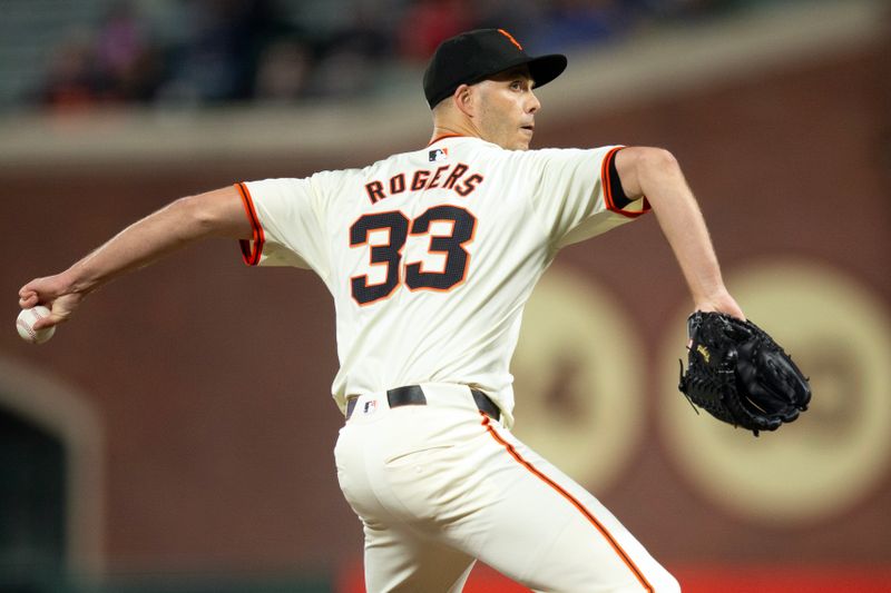 Aug 14, 2024; San Francisco, California, USA; San Francisco Giants pitcher Taylor Rogers (33) delivers a pitch against the Atlanta Braves during the eighth inning at Oracle Park. Mandatory Credit: D. Ross Cameron-USA TODAY Sports