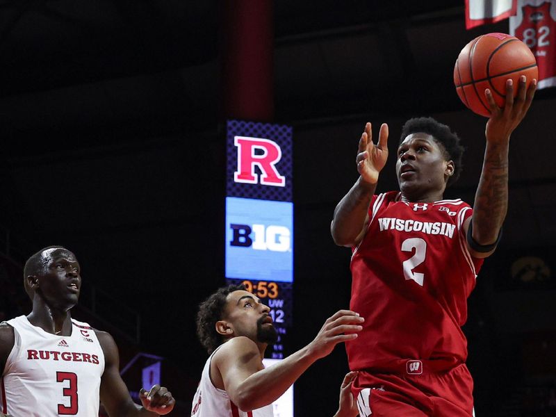 Feb 10, 2024; Piscataway, New Jersey, USA; Wisconsin Badgers guard AJ Storr (2) drives for a shot against Rutgers Scarlet Knights guard Noah Fernandes (2) and forward Mawot Mag (3) during the first half at Jersey Mike's Arena. Mandatory Credit: Vincent Carchietta-USA TODAY Sports