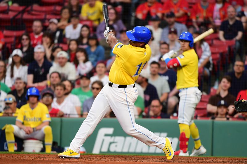 May 3, 2025; Boston, Massachusetts, USA; Boston Red Sox designated hitter Rafael Devers (11) hits an RBI single during the seventh inning against the Minnesota Twins at Fenway Park. Mandatory Credit: Bob DeChiara-Imagn Images