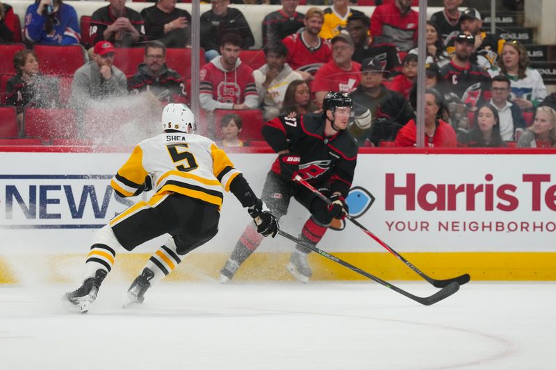 Mar 10, 2026; Raleigh, North Carolina, USA;  Carolina Hurricanes right wing Andrei Svechnikov (37) skates with the puck against Pittsburgh Penguins defenseman Ryan Shea (5) during the first period at Lenovo Center. Mandatory Credit: James Guillory-Imagn Images