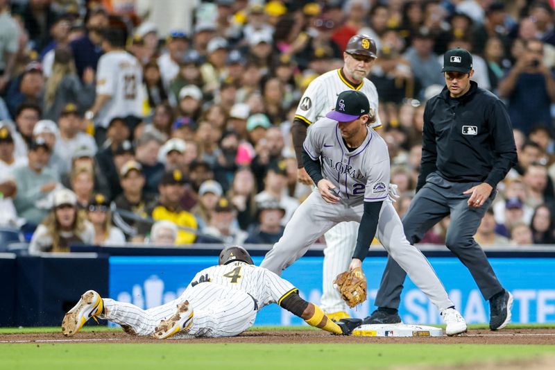 Apr 12, 2025; San Diego, California, USA; San Diego Padres first baseman Luis Arraez (4) avoids being picked off at third base during the sixth inning against the Colorado Rockies at Petco Park. Mandatory Credit: David Frerker-Imagn Images