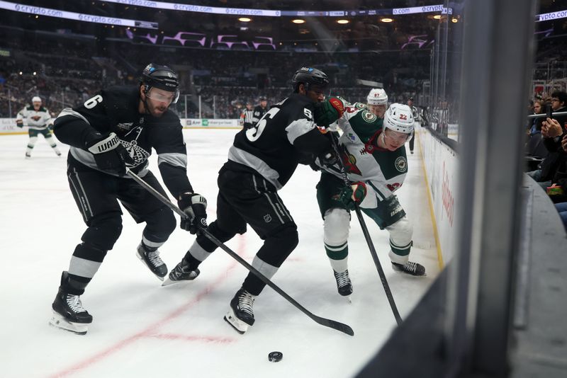 Jan 3, 2026; Los Angeles, California, USA;  Minnesota Wild right wing Danila Yurov (22) fights for the puck against Los Angeles Kings defenseman Joel Edmundson (6) and right wing Quinton Byfield (55) during the third period at Crypto.com Arena. Mandatory Credit: Kiyoshi Mio-Imagn Images