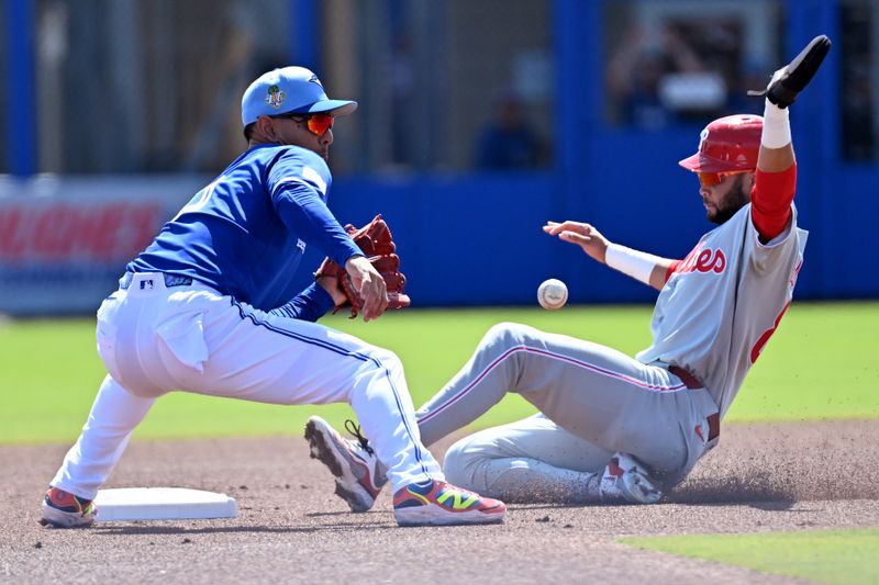 Feb 28, 2026; Dunedin, Florida, USA;  Philadelphia Phillies center fielder Justin Crawford (80) slides into second base as Toronto Blue Jays shortstop Andres Gimenez (0) waits for the ball during spring training at TD Ballpark. Mandatory Credit: Jonathan Dyer-Imagn Images