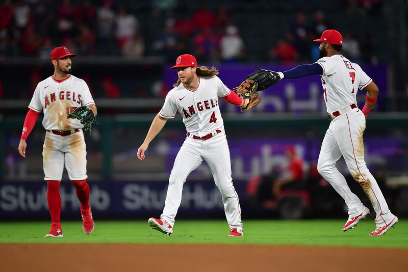 Sep 26, 2023; Anaheim, California, USA; Los Angeles Angels left fielder Randal Grichuk (15) center fielder Brett Phillips (4) and right fielder Jo Adell (7) celebrate the victory against the Texas Rangers at Angel Stadium. Mandatory Credit: Gary A. Vasquez-USA TODAY Sports