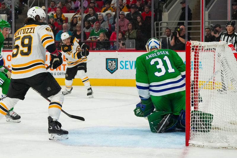 Mar 26, 2023; Raleigh, North Carolina, USA;  Boston Bruins right wing David Pastrnak (88) scores a goal on his shot past Carolina Hurricanes goaltender Frederik Andersen (31) during the second period at PNC Arena. Mandatory Credit: James Guillory-USA TODAY Sports