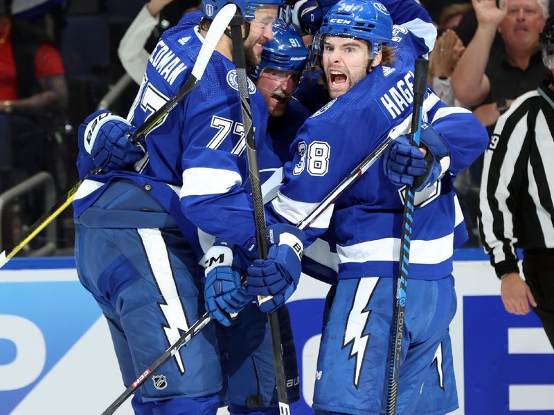 Apr 27, 2024; Tampa, Florida, USA; Tampa Bay Lightning center Steven Stamkos (91) is congratulated by center Brayden Point (21), left wing Brandon Hagel (38) and defenseman Victor Hedman (77) after he scored a goal against the Florida Panthers during the first period in game four of the first round of the 2024 Stanley Cup Playoffs at Amalie Arena. Mandatory Credit: Kim Klement Neitzel-USA TODAY Sports