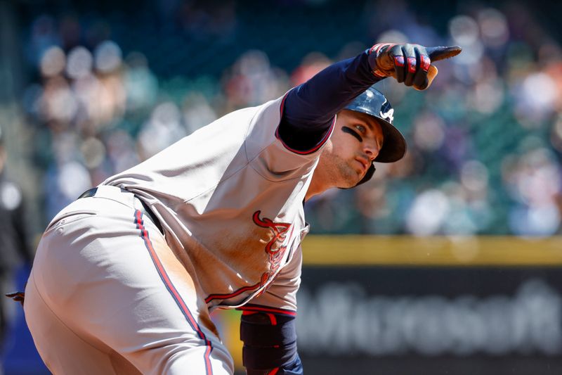 May 1, 2024; Seattle, Washington, USA; Atlanta Braves third baseman Austin Riley (27) reacts towards the dugout after hitting a two-run triple against the Seattle Mariners during the fourth inning at T-Mobile Park. Mandatory Credit: Joe Nicholson-USA TODAY Sports
