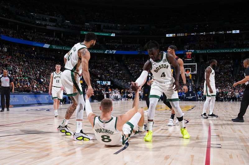 DENVER, CO - MARCH 7: Kristaps Porzingis #8 is helped up by Jayson Tatum #0 and Jrue Holiday #4 of the Boston Celtics during the game against the Denver Nuggets on March 7, 2024 at the Ball Arena in Denver, Colorado. NOTE TO USER: User expressly acknowledges and agrees that, by downloading and/or using this Photograph, user is consenting to the terms and conditions of the Getty Images License Agreement. Mandatory Copyright Notice: Copyright 2024 NBAE (Photo by Garrett Ellwood/NBAE via Getty Images)