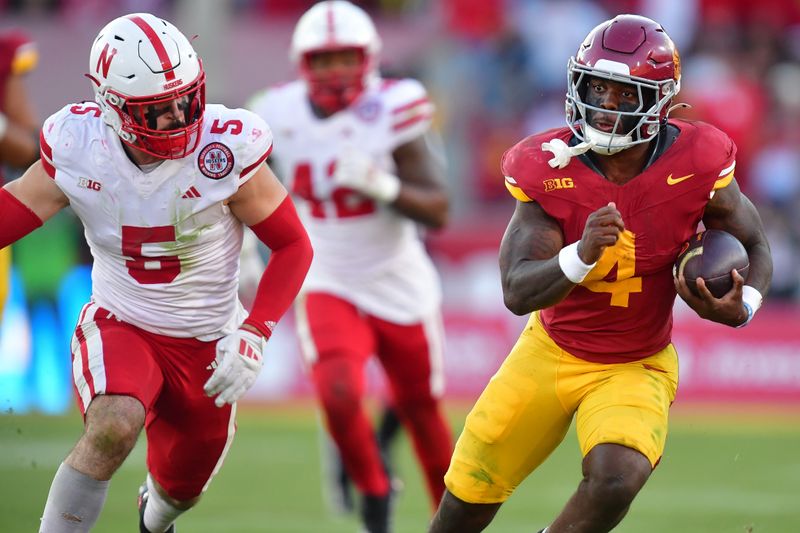 Nov 16, 2024; Los Angeles, California, USA; Southern California Trojans running back Woody Marks (4) runs the ball ahead of Nebraska Cornhuskers linebacker John Bullock (5) during the second half at the Los Angeles Memorial Coliseum. Mandatory Credit: Gary A. Vasquez-Imagn Images