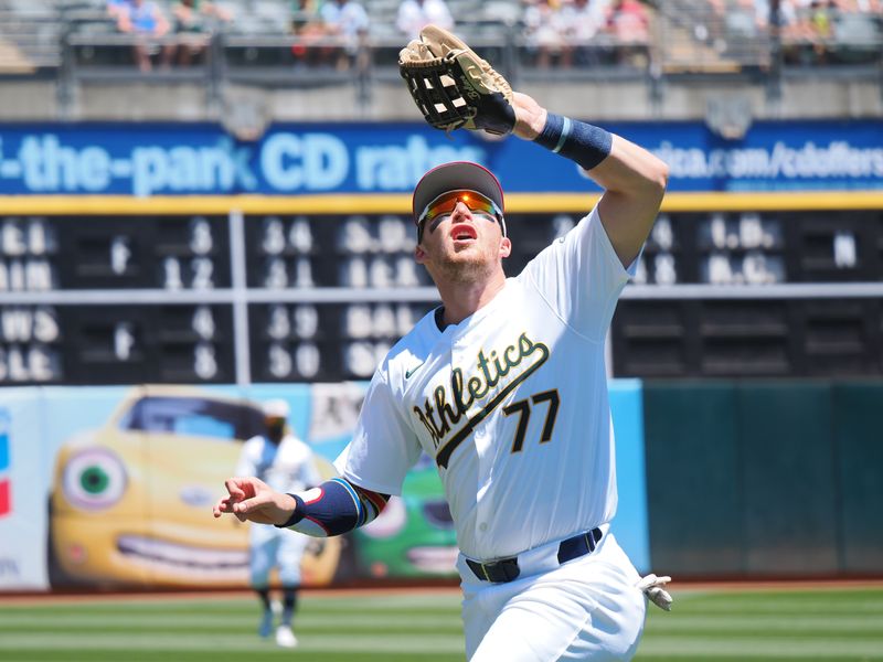 Jul 4, 2024; Oakland, California, USA; Oakland Athletics third baseman Brett Harris (77) catches the ball against the Los Angeles Angels during the first inning at Oakland-Alameda County Coliseum. Mandatory Credit: Kelley L Cox-USA TODAY Sports